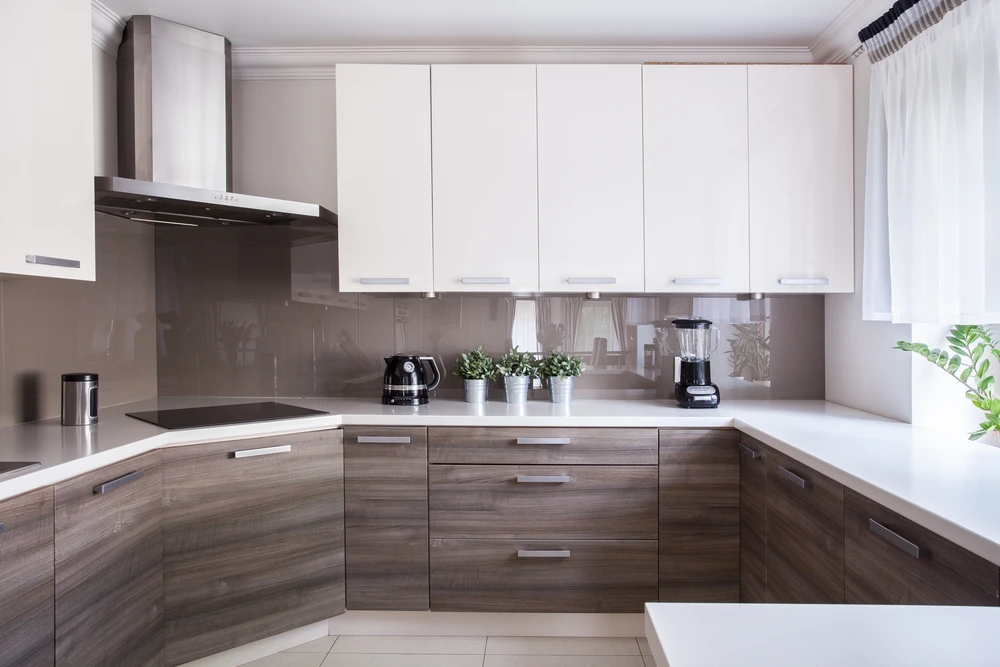 Cuisine moderne en L avec façade bicolore, meubles bas en bois stratifié et meubles hauts blancs laqués