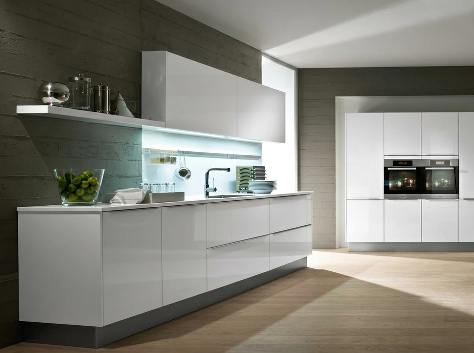 Cuisine moderne avec plan de travail blanc, façade en bois sombre et fenêtres panoramiques donnant sur jardin paysager