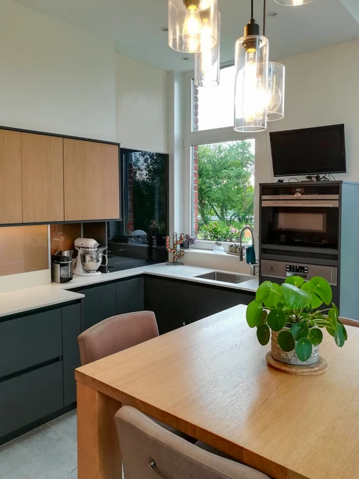 Cuisine moderne en L avec façade bicolore, meubles bas en bois stratifié et meubles hauts blancs laqués