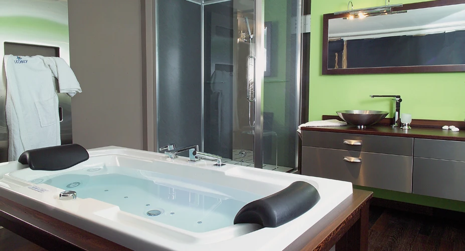 Salle de bain moderne luxueuse avec baignoire îlot centrale et douche à l'italienne séparée par cloison vitrée