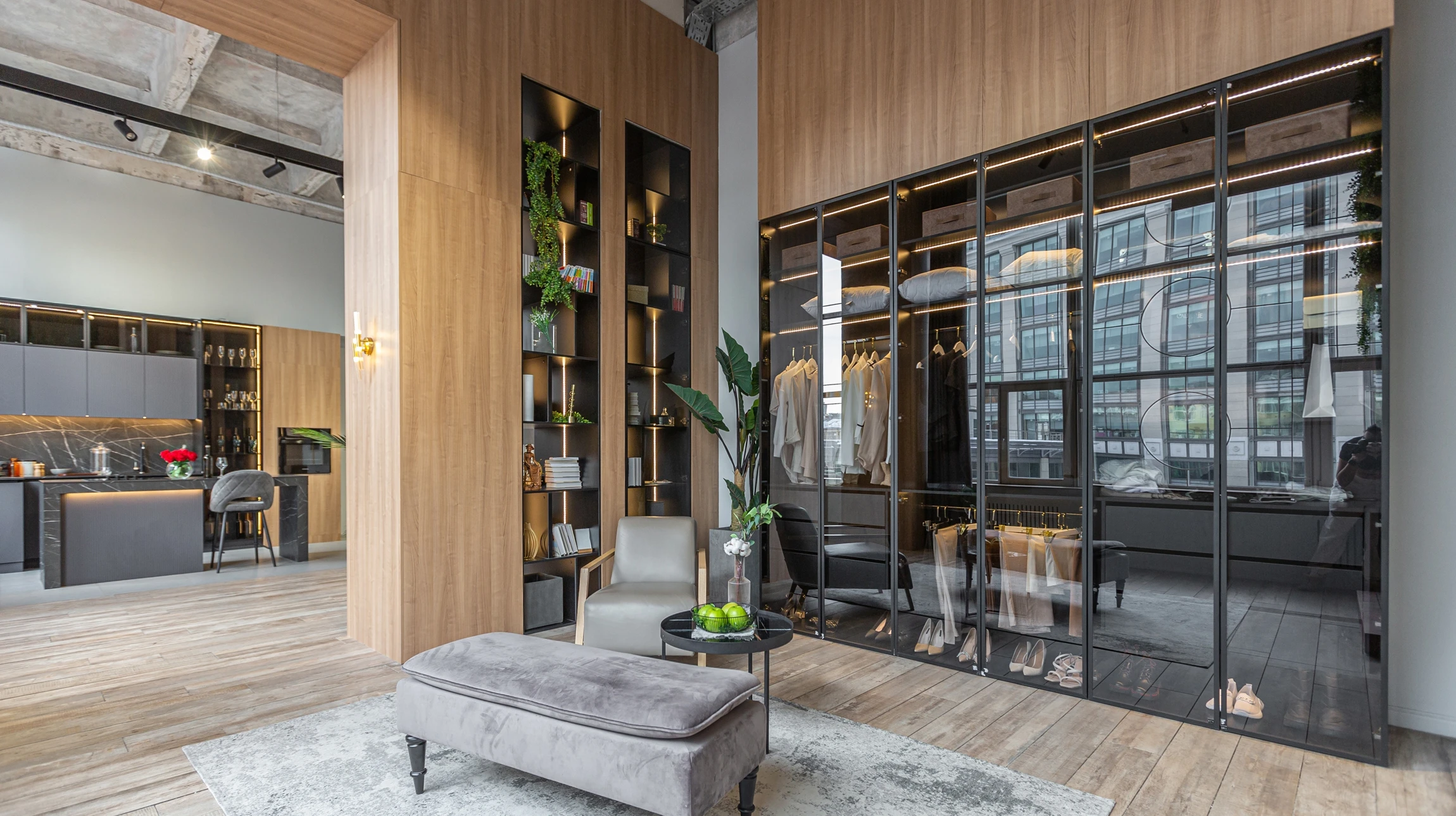 Photographie d'un dressing sur mesure moderne et lumineux avec portes blanches intégrées au mur, penderies, étagères bois clair et rangements organisés, montrant l'optimisation intelligente de l'espace et la qualité des aménagements haut de gamme de LéoBey.