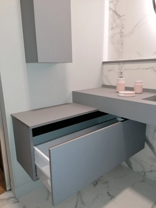 Salle de bain moderne avec double vasque, meuble bas bleu marine à tiroirs et portes, quincaillerie laiton